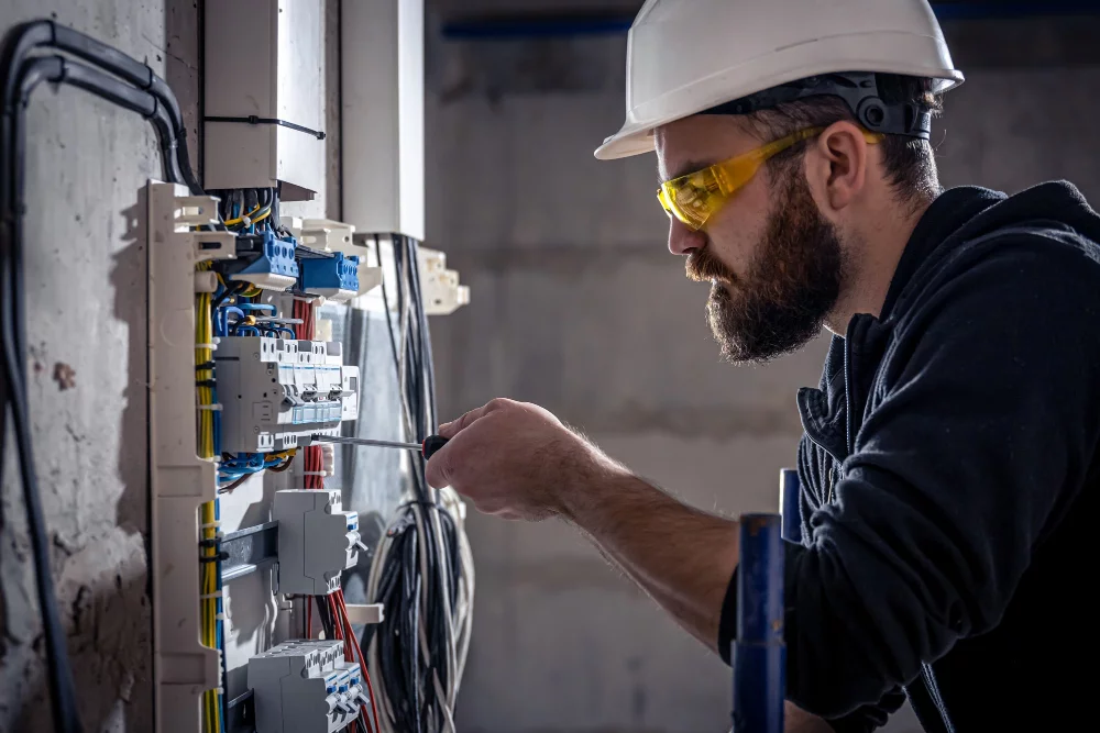 male-electrician-works-switchboard-with-electrical-connecting-cable